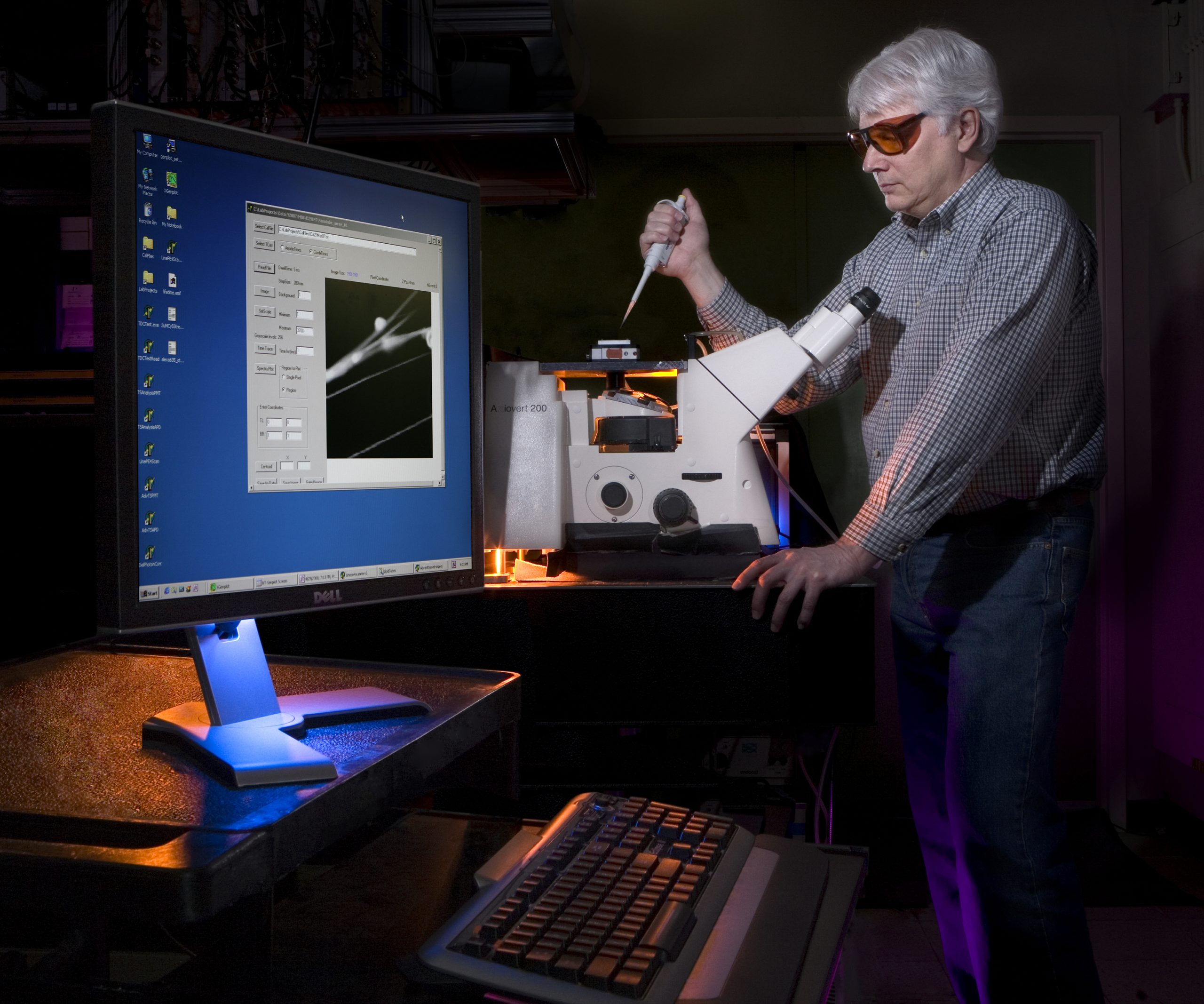 Sandia researcher Carl Hayden positions a sample on the spectrally resolved, confocal imaging microscope.<br />
Download 300dpi 21MB JPEG image (Media are welcome to download/publish this image with related news stories.)