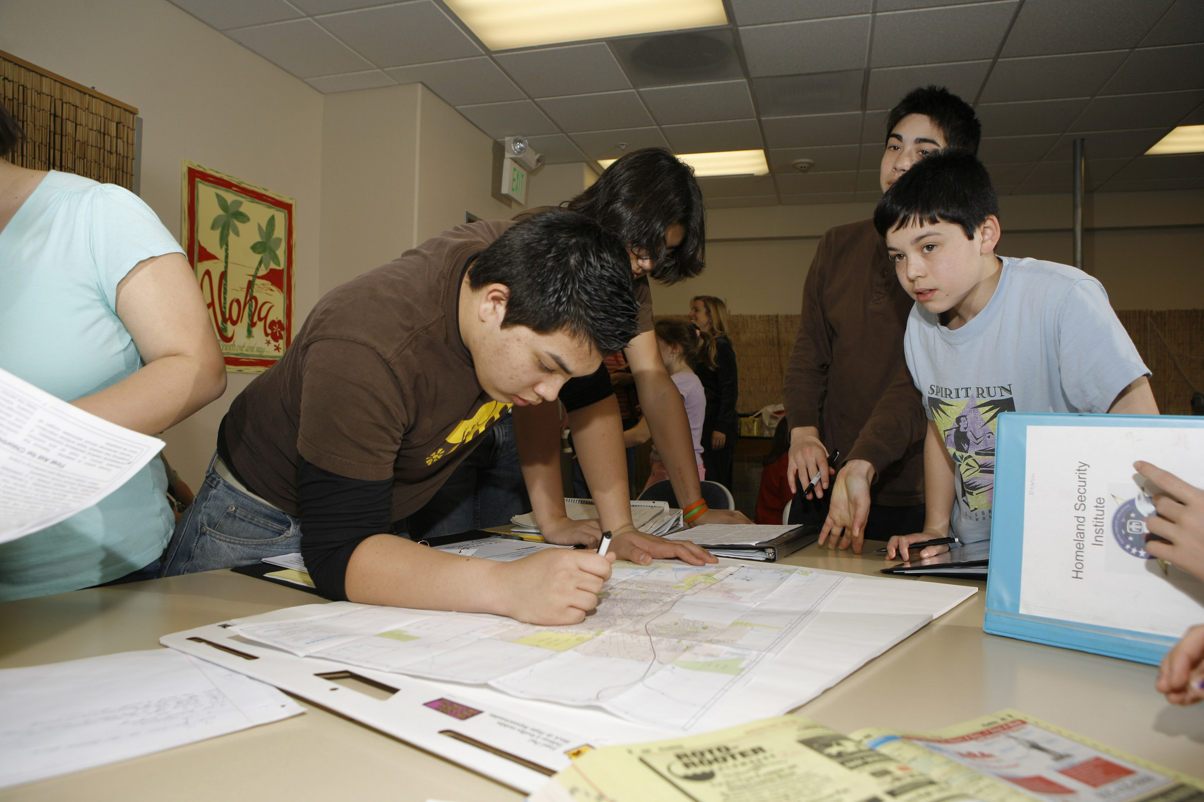 A group of Livermore students role-playing as Federal emergency response personnel review documents relating to a mock disaster scenario. Sandia’s High School Homeland Security program helps students think outside the box and recognize the complexities of real-world situations.