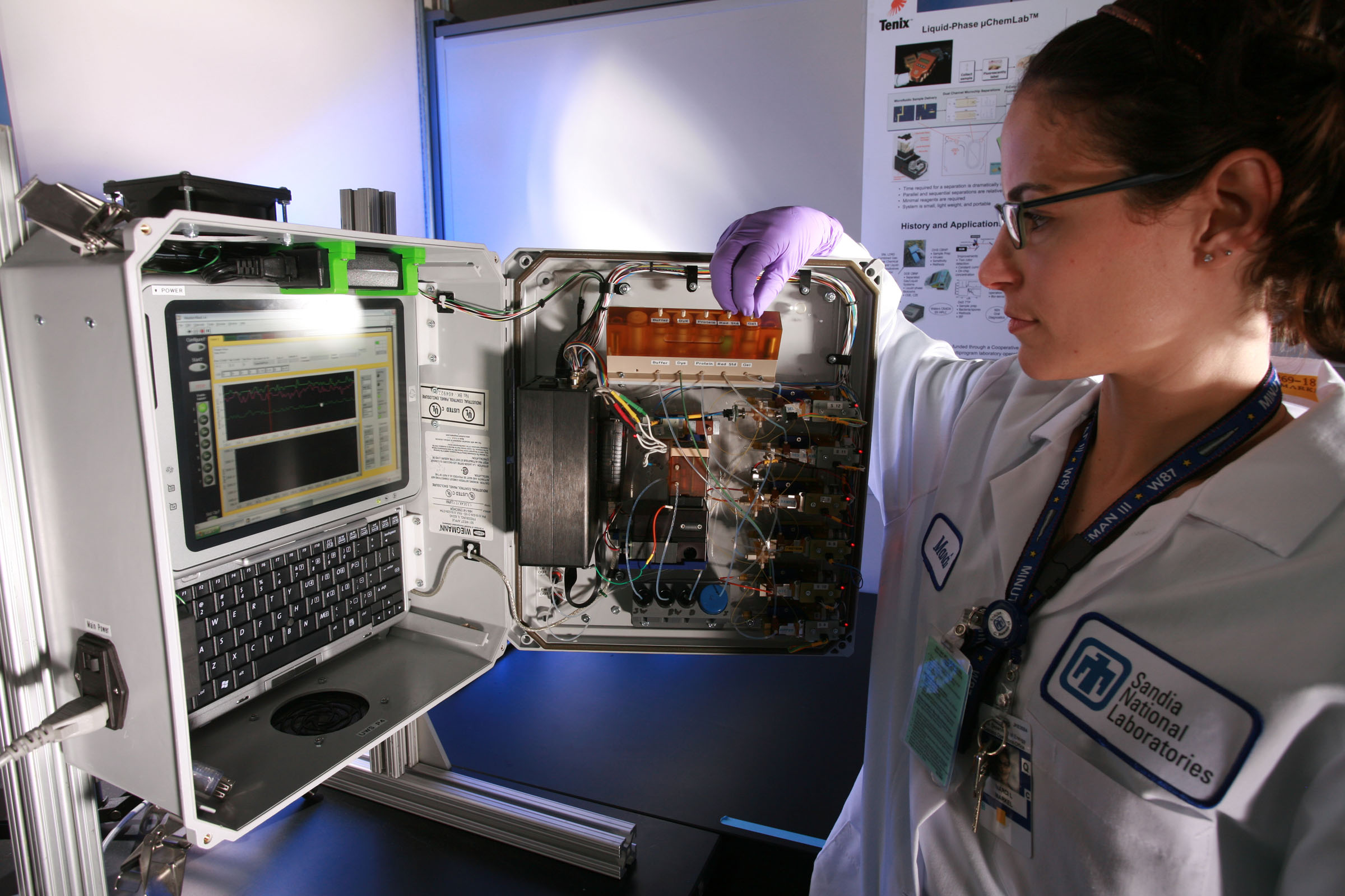 Sandia engineer Marci Markel displays the inside of the unattended water sensor. The UWS diagnostic instrumentation package is composed of analytic instruments, pumps, tubes, and small reservoirs to handle minute amounts of fluid. The technology is largely based on Sandia’s well-known µChemLab.