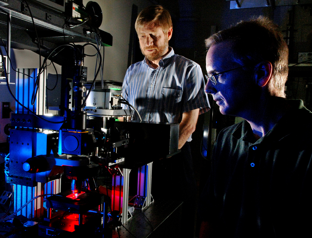 Sandia National Laboratories researchers Michael Sinclair (foreground) and David Haaland prepare a hyperspectral confocal microscope for measurement of a biological specimen. The new microscope, shown on the left, was designed and fabricated at Sandia. (Photo by Randy Montoya)<br />
Download 300dpi 6MB JPEG image (Media are welcome to download/publish this image with related news stories.)