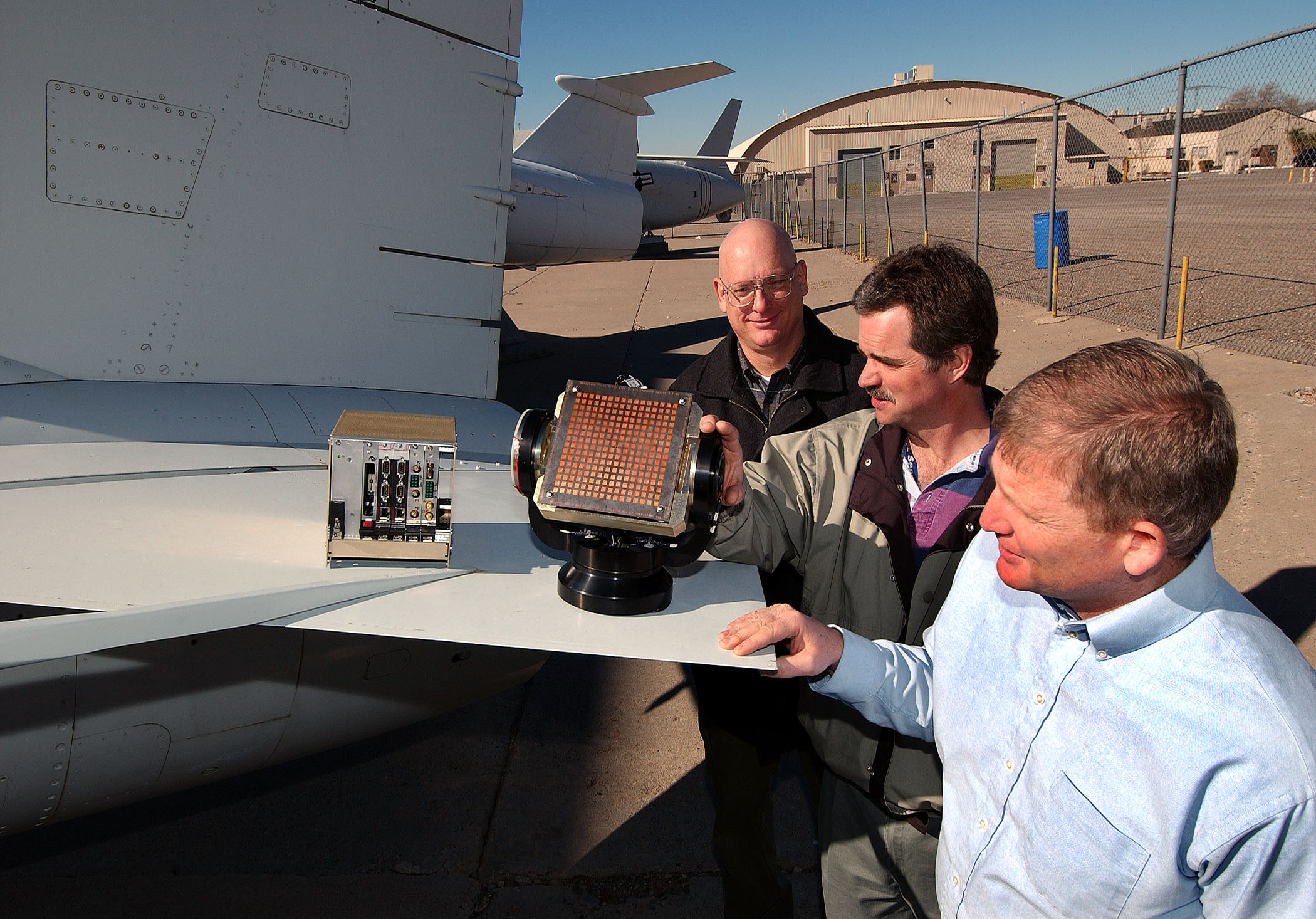 Sandia researchers, from front to back, George Sloan, Dale Dubbert, and Armin Doerry, check out an early version of MiniSAR. (Photo by Randy Montoya)
