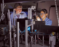 Sandia optical tweezer designer Thomas Perroud assists biologist Meiye Wu with sorting of macrophage cells in microfluidic devices using MISL technology. (Photo by Randy Wong)