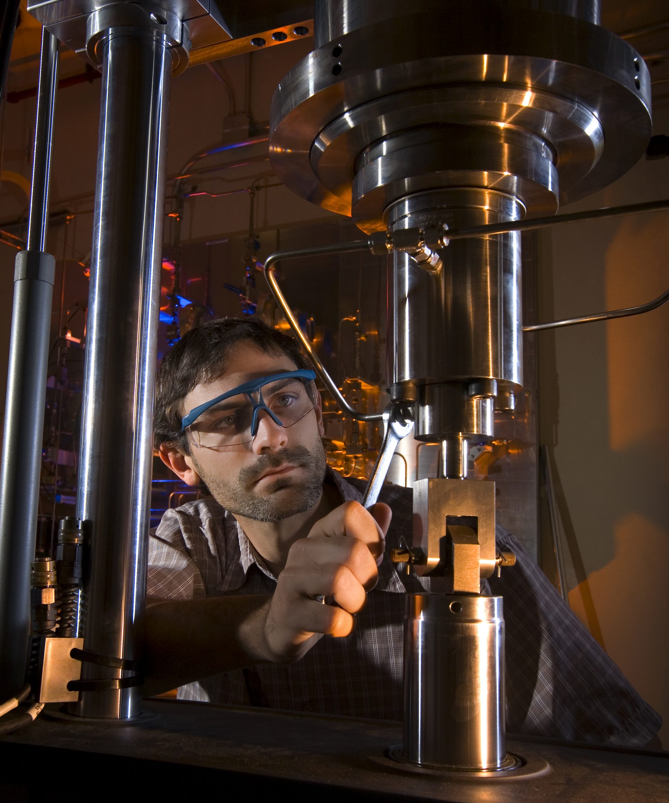 Sandia postdoc Kevin Nibur assembles a pressure vessel and manifold on a mechanical test frame for a test of how containment materials react to dynamic loads in high-pressure hydrogen gas. This high-pressure hydrogen test lab is the only one of its kind in the U.S. and only one of three in the world. (Photo by Randy Wong)<br />
Download 300dpi 21MB JPEG image (Media are welcome to download/publish this image with related news stories.)