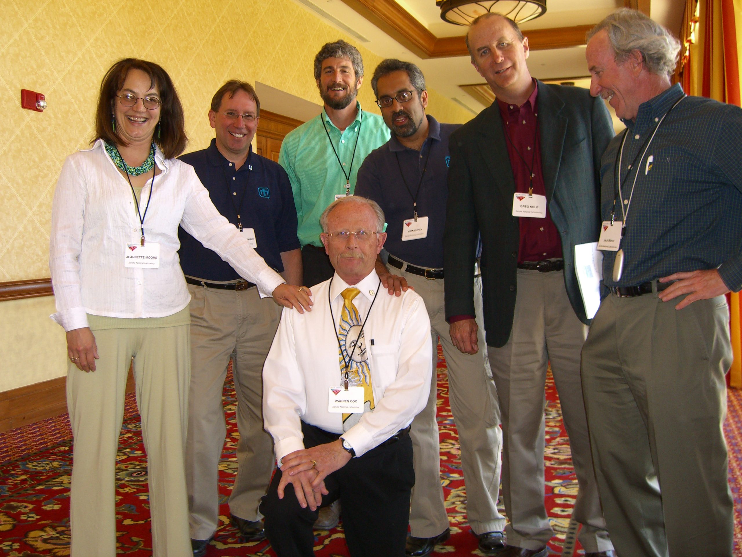 Sandia’s Tiger Team members relaxing for a group shot at the 1st annual Solar America Cities meeting in Tucson are (standing, left to right) Jeannette Moore, Andrew Kazensky, Howard Passell, Vipin Gupta, Greg Kolb, and Jack Mizner. Kneeling is Warren Cox. Present but not in the photo were Sandra Begay-Campbell, Beth Richards, and Charlie Hanley. Dick Fate, another team member, was occupied elsewhere.<br />
Download 300dpi 4.8MB JPEG image (Media are welcome to download/publish this image with related news stories.)