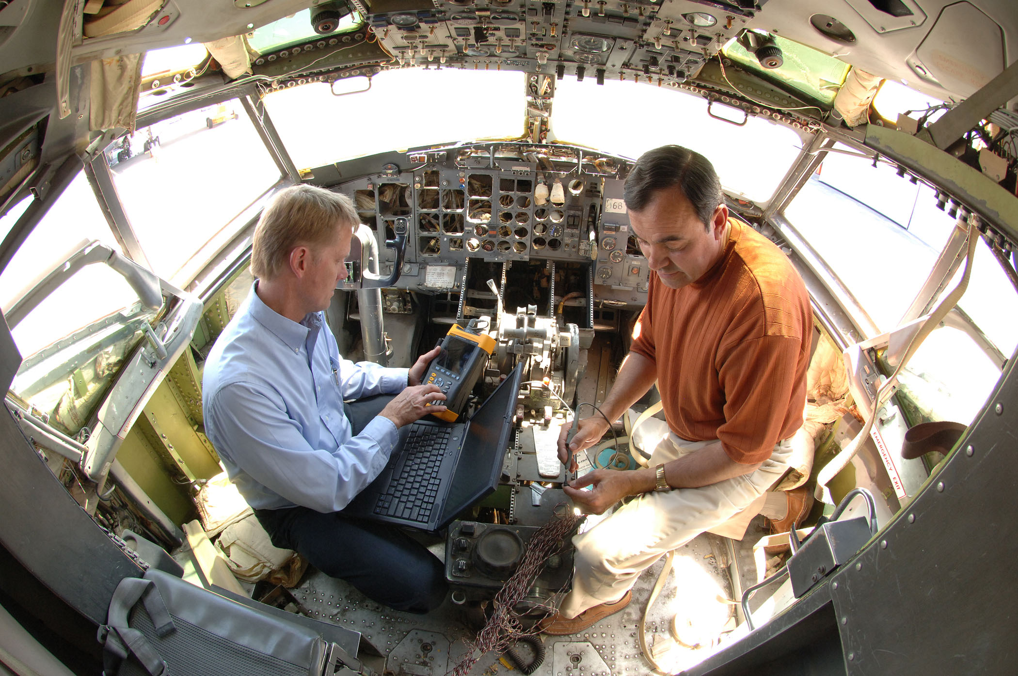 Mike Dinallo and Larry Schneider (left) prepare to employ the PASD diagnostic on a wiring bundle in the cockpit of a retired Boeing 737 at Sandia’s FAA Airworthiness Assurance NDI Validation Center. (Photo by Randy Montoya)
