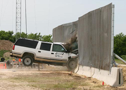 In the crash test seen here, a vehicle collides with a surface-mounted barrier that includes anti-personnel fence on top of the vehicle barrier.