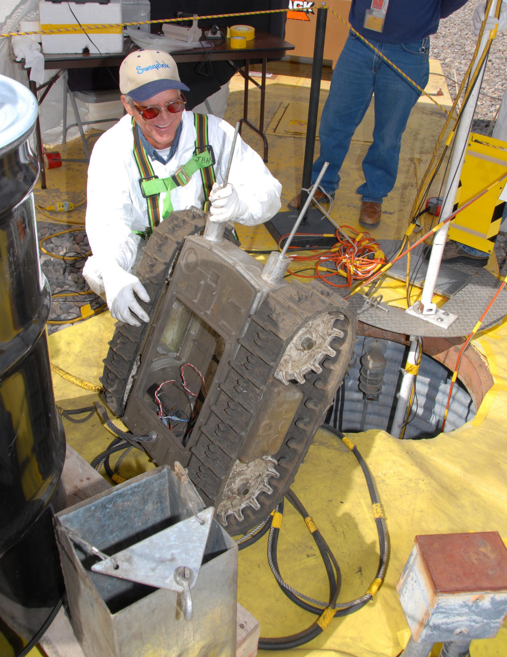 DOUG EVANS INSPECTS SWARMY after its tour of duty in the wastewater storage tank. (Photo by Randy Montoya)