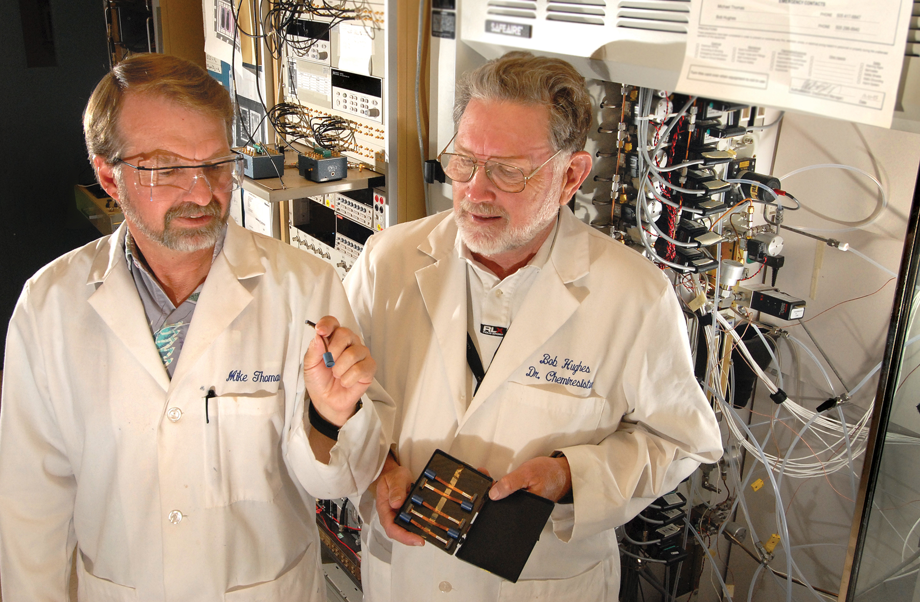 Sandia researchers Mike Thomas, left, and Bob Hughes work with the Wide-Range Hydrogen Sensor, developed at Sandia and commercialized by H2scan after a complex tech transfer process.