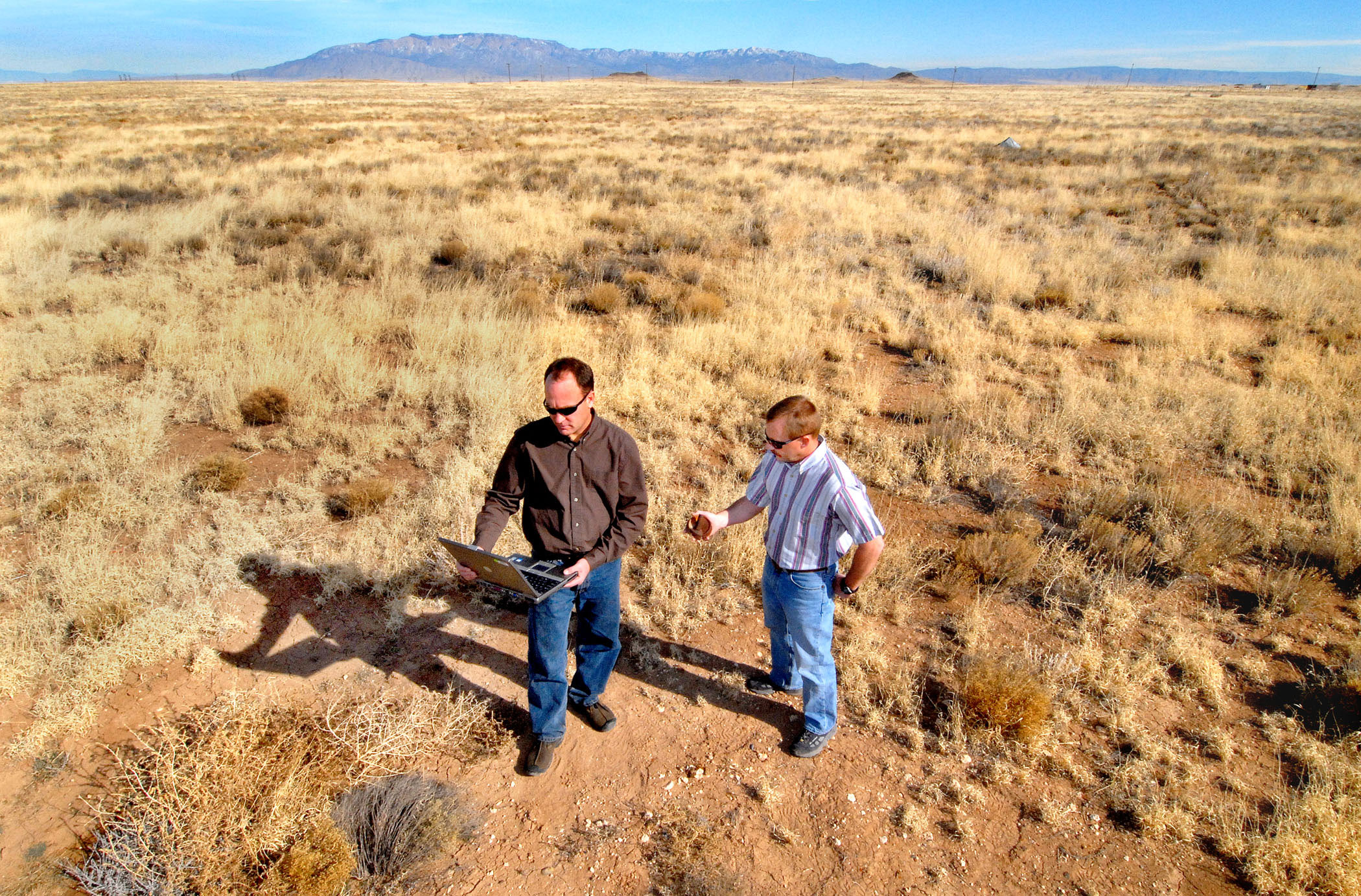 Sandia researchers Sean McKenna and Barry Roberts check data that confirms the location of metal fragments associated with the old Kirtland bombing range on Albuquerque’s West Side.