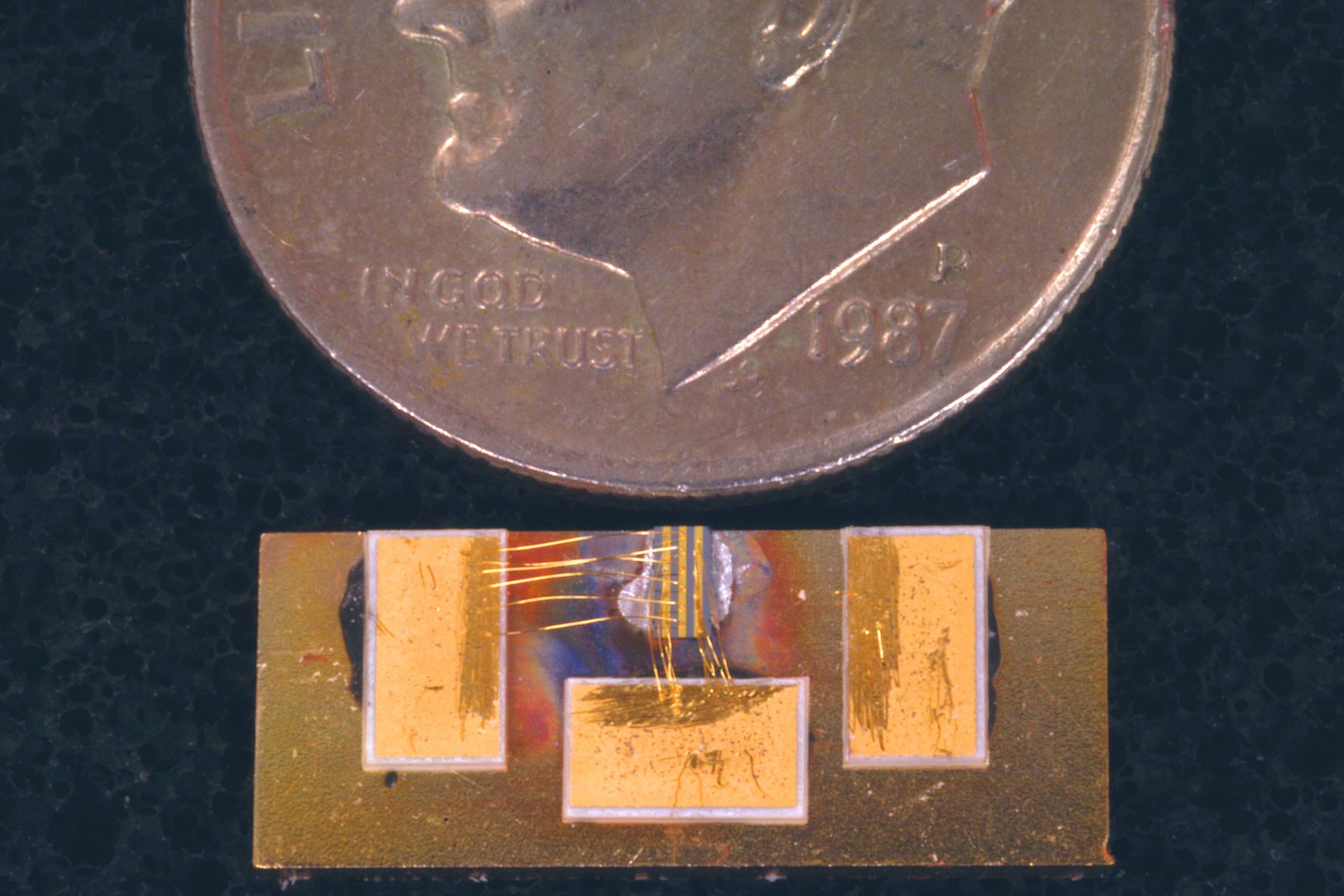 MINIATURIZED DEVICE shown next to a dime.