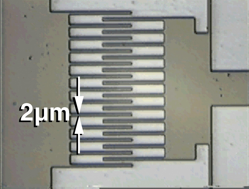 DIAMOND COMBS -- Sandia National Laboratories researchers have created the world's first diamond micromachine in this comb drive that drives a tiny diamond piston. The drive is powered by a tiny alternating electrical current. As the two sets of comb teeth repel and attract each other, one comb slides back and forth. Amorphous diamond reduces stiction -- a combination of stickiness and friction. Use of diamond as a construction material is expected to dramatically increase the durability of the tiny machines, which are about the size of pollen grains.