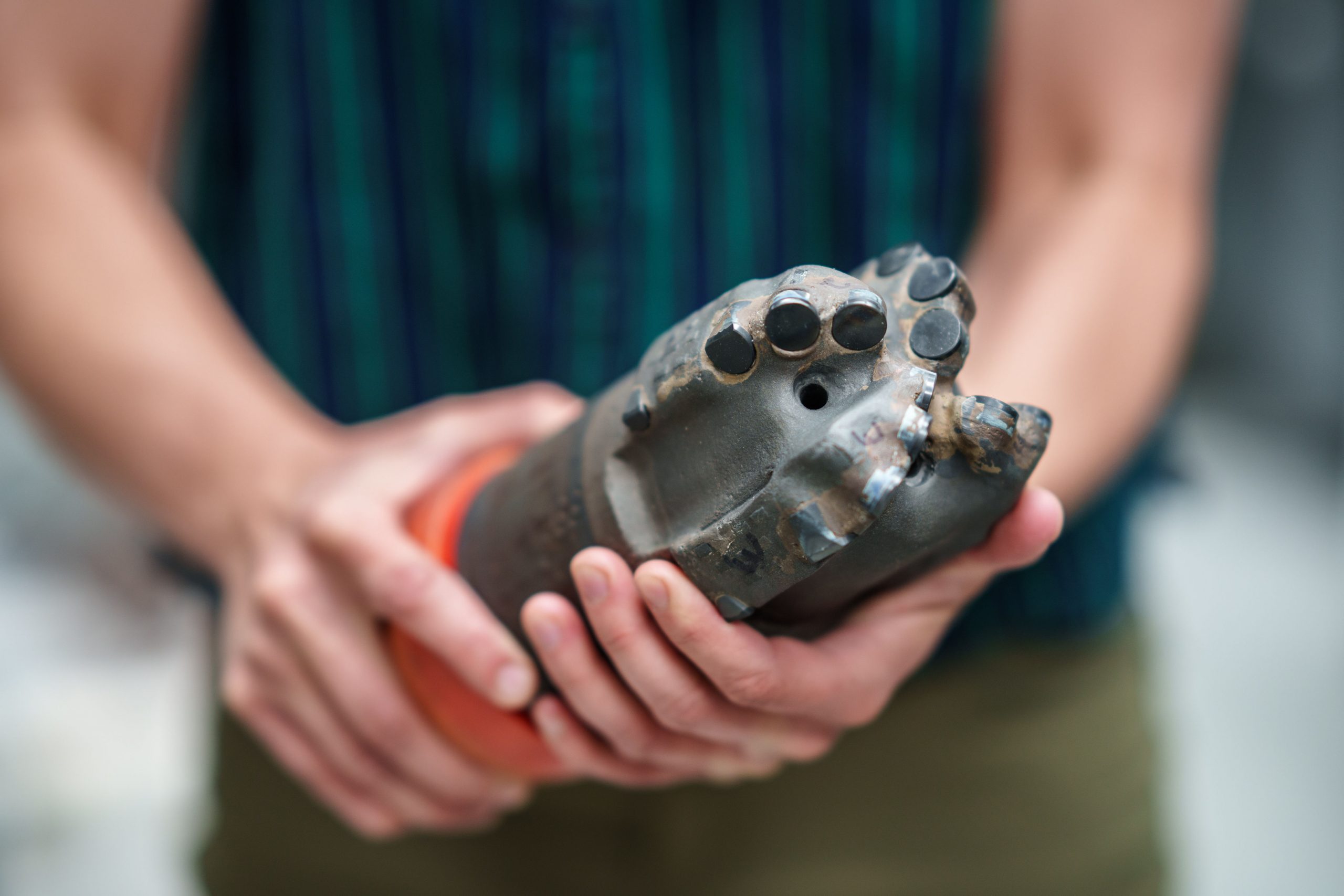 Sandia National Laboratories mechanical engineer Melanie Schneider holds a polycrystalline diamond compact bit. Despite decades of research at Sandia and elsewhere, only recently have such bits become viable for geothermal well drilling. 
