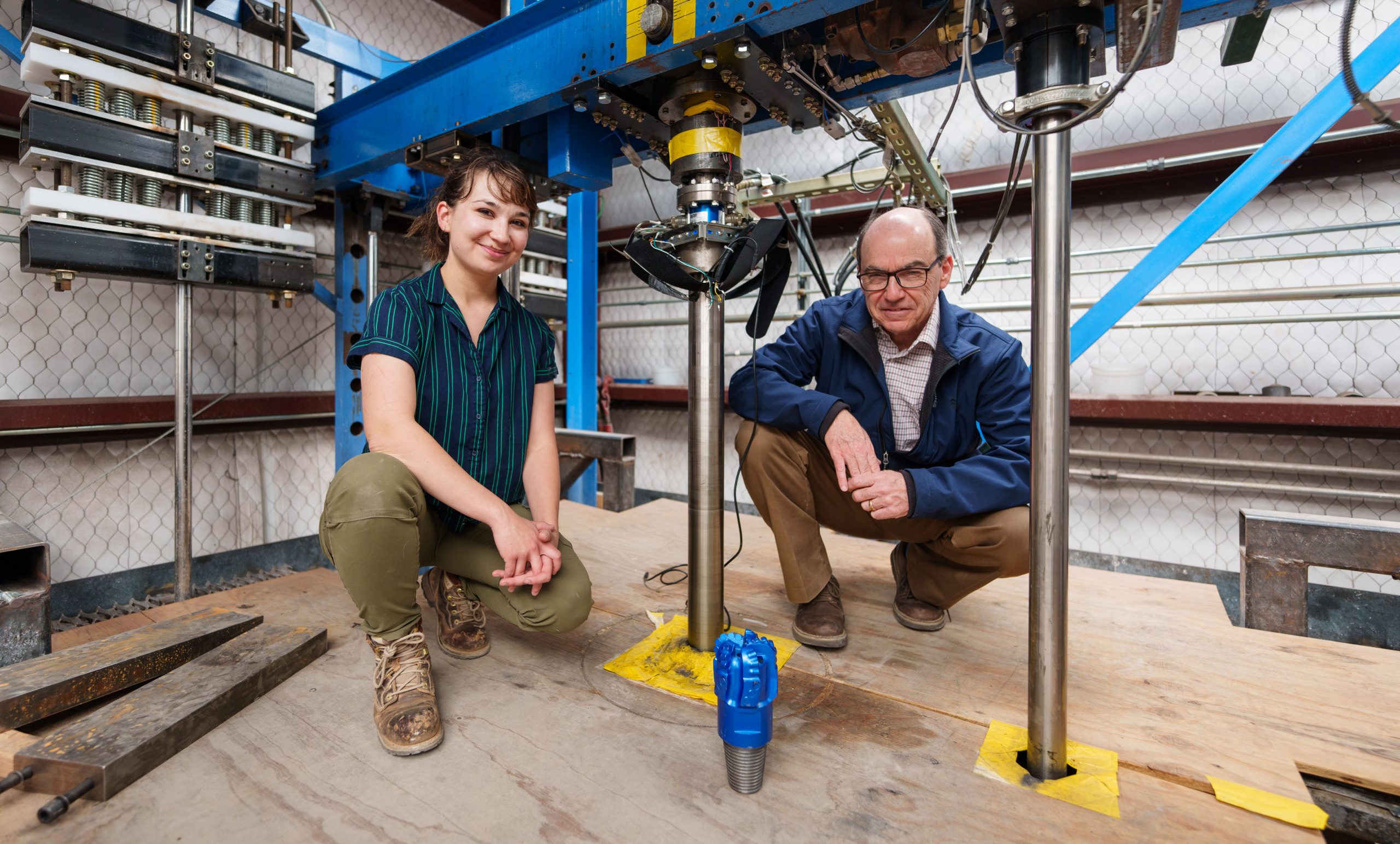 Sandia National Laboratories mechanical engineers David Raymond, right, and Melanie Schneider pose in Sandia’s Hard Rock Drilling Facility with a polycrystalline diamond compact bit. They recently completed an analysis on bit performance for geothermal well drilling. 