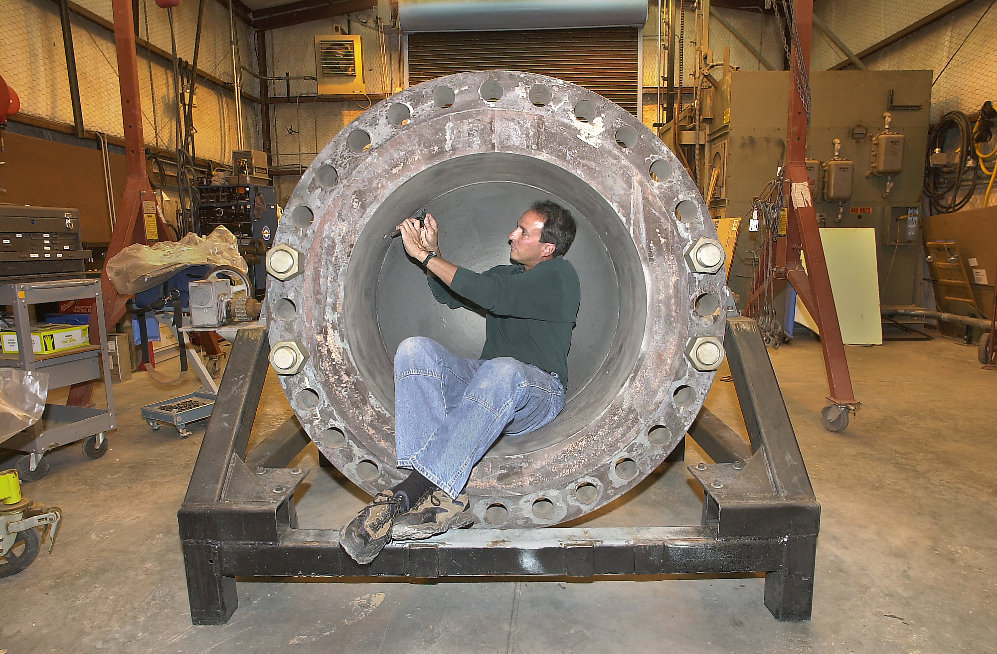 Sandia National Laboratories test engineer Richard Simpson measures a weld seam inside a 1/5-scale model lower-head assembly.