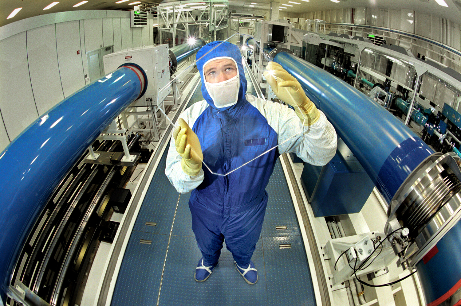 SURROUNDED BY Z-BEAMLET — Sandia technologist Benjamin Thurston examines the debris shield that protects the giant Z-Beamlet laser’s final focusing lens from flying debris when the Z accelerator fires. The lens is square because the beam generates an approximately 12-inch-square footprint, like a kind of flying pancake, until focused down to approximately 100 microns.