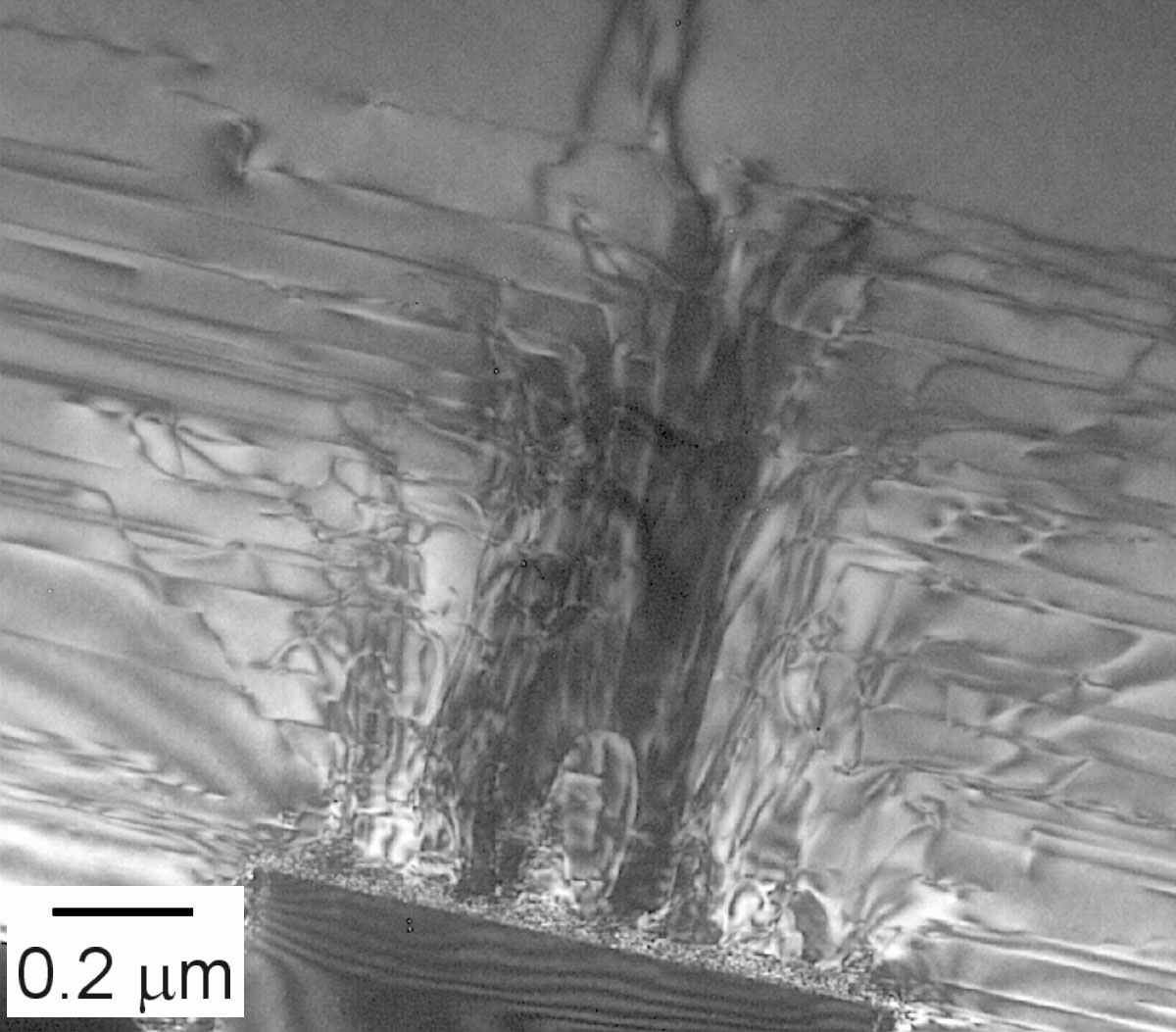 Cross-section TEM image of cantilever epitaxial gallium nitride. Dislocations growing vertically over the sapphire post at bottom are turned to horizontal in the gallium nitride by the 950 °C growth step so that only a few percent of them continue to the top surface. (Photo by Randy Montoya)