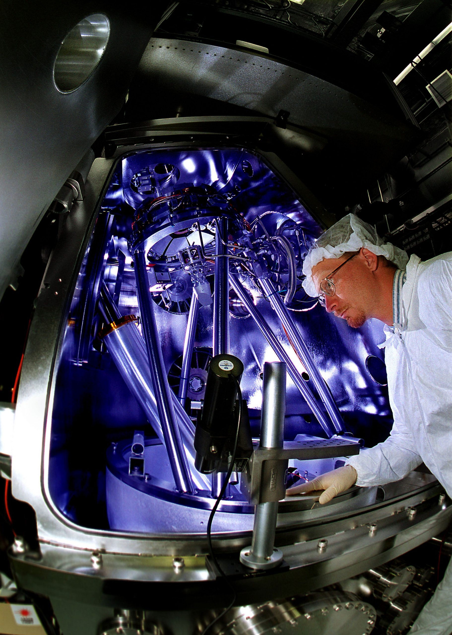 RESEARCHER Kevin Krenz inspects components in the first-generation Extreme Ultraviolet Lithography tool. EUVL was one of seven R&D 100 awards won by Sandia in 2003.(Photo by Randy Montoya)