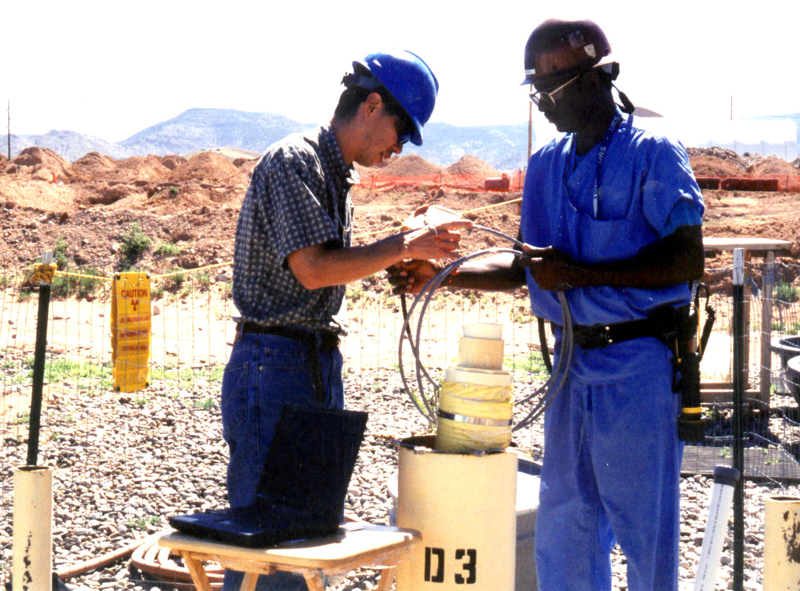 Sandia researches Cliff Ho and Henry Bryant deploy a chemiresistor package at Sandia’s Chemical Waste Landfill as part of a field test.