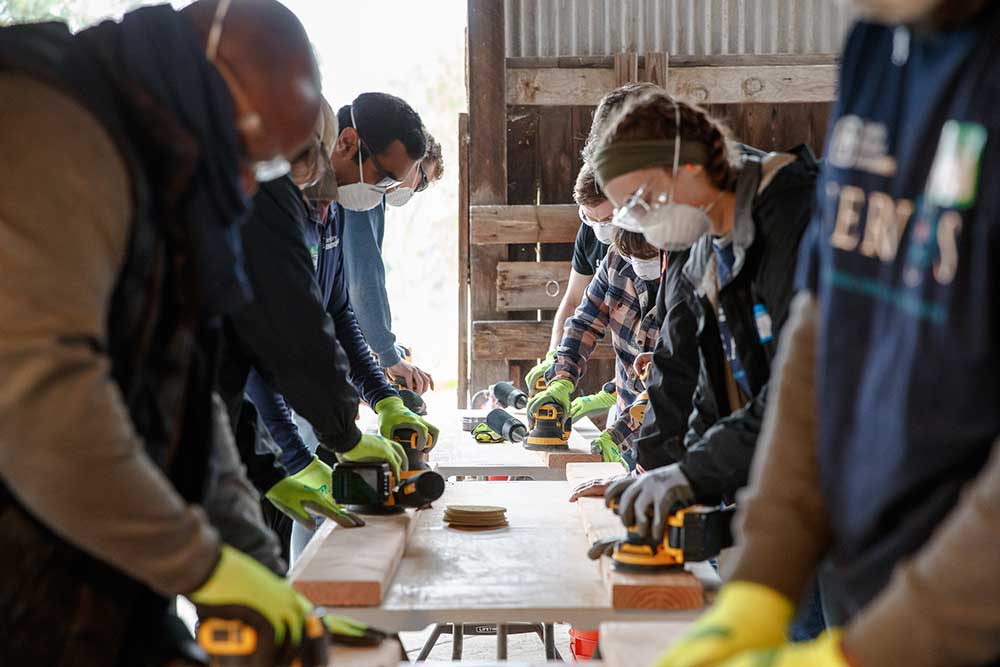 Sandia National Laboratories employees in California sand 2x4’s as part of a project to build beds for the organization Sleep in Heavenly Peace.
