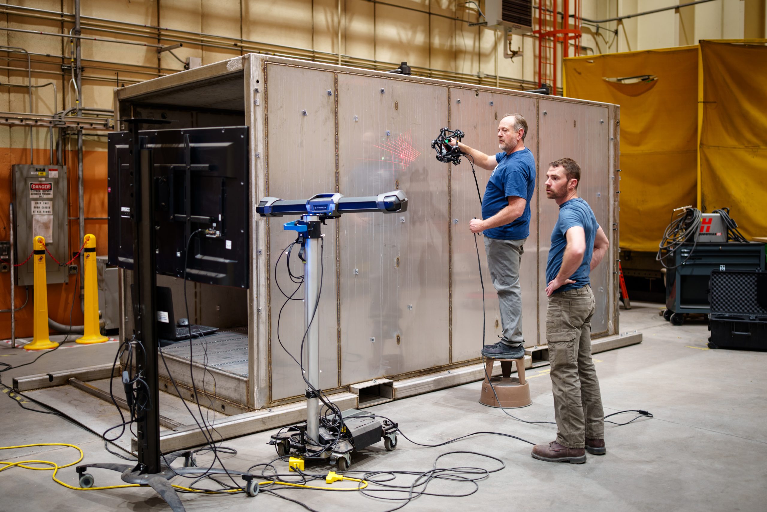 An engineer performs a 3D scan of the Mobile Vault while another verifies the results. The Mobile Vault was designed and demonstrated by a team at Sandia National Laboratories. 