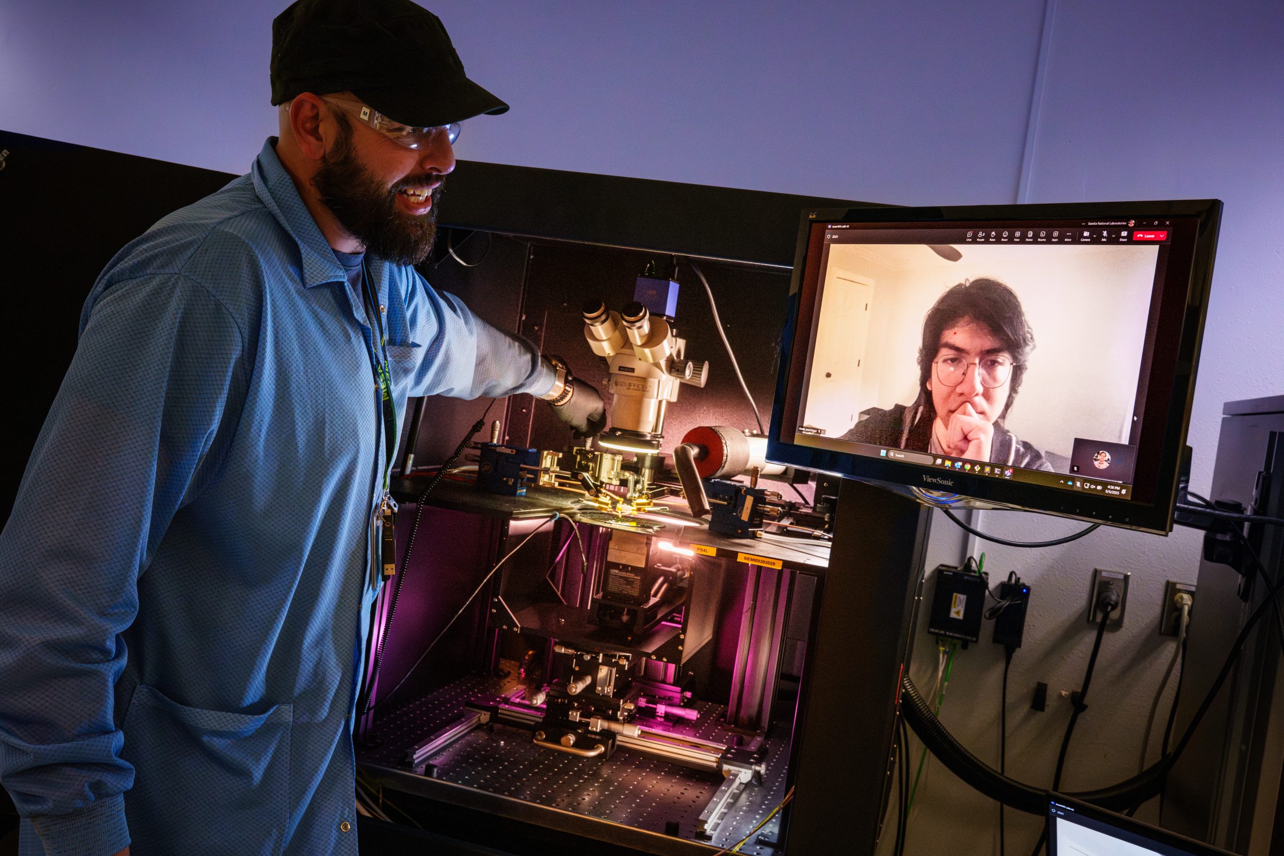 Sandia National Laboratories electronic device engineer Robin Jacobs-Gedrim, left, assists SIGMA intern Jared Arzate as he remotely operates a device to test the effect of temperature on brain-inspired computing devices. 