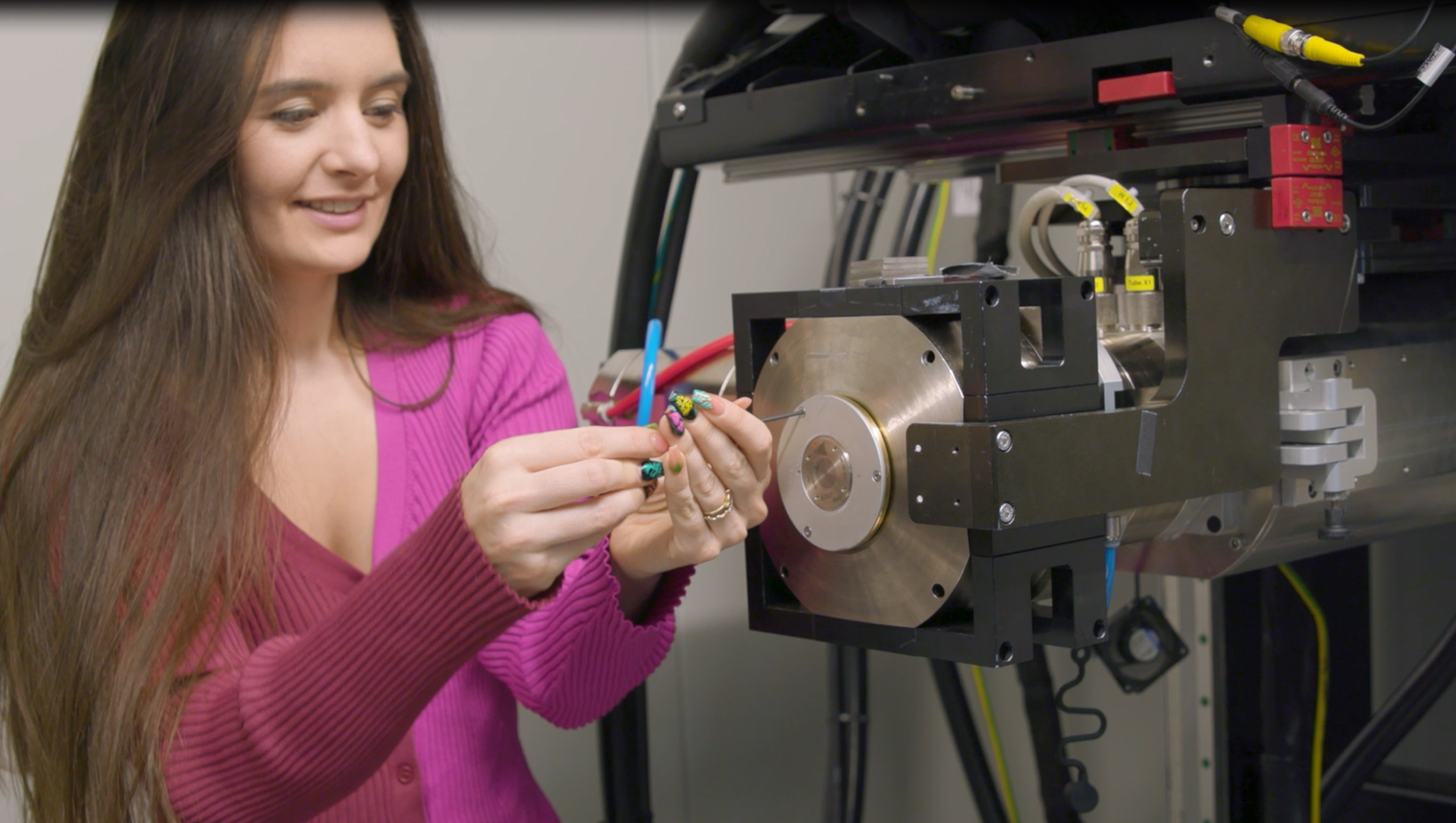 Noelle Collins, mounts the packaged multi-metal patterned target on the X-ray tube at Sandia National Laboratories.