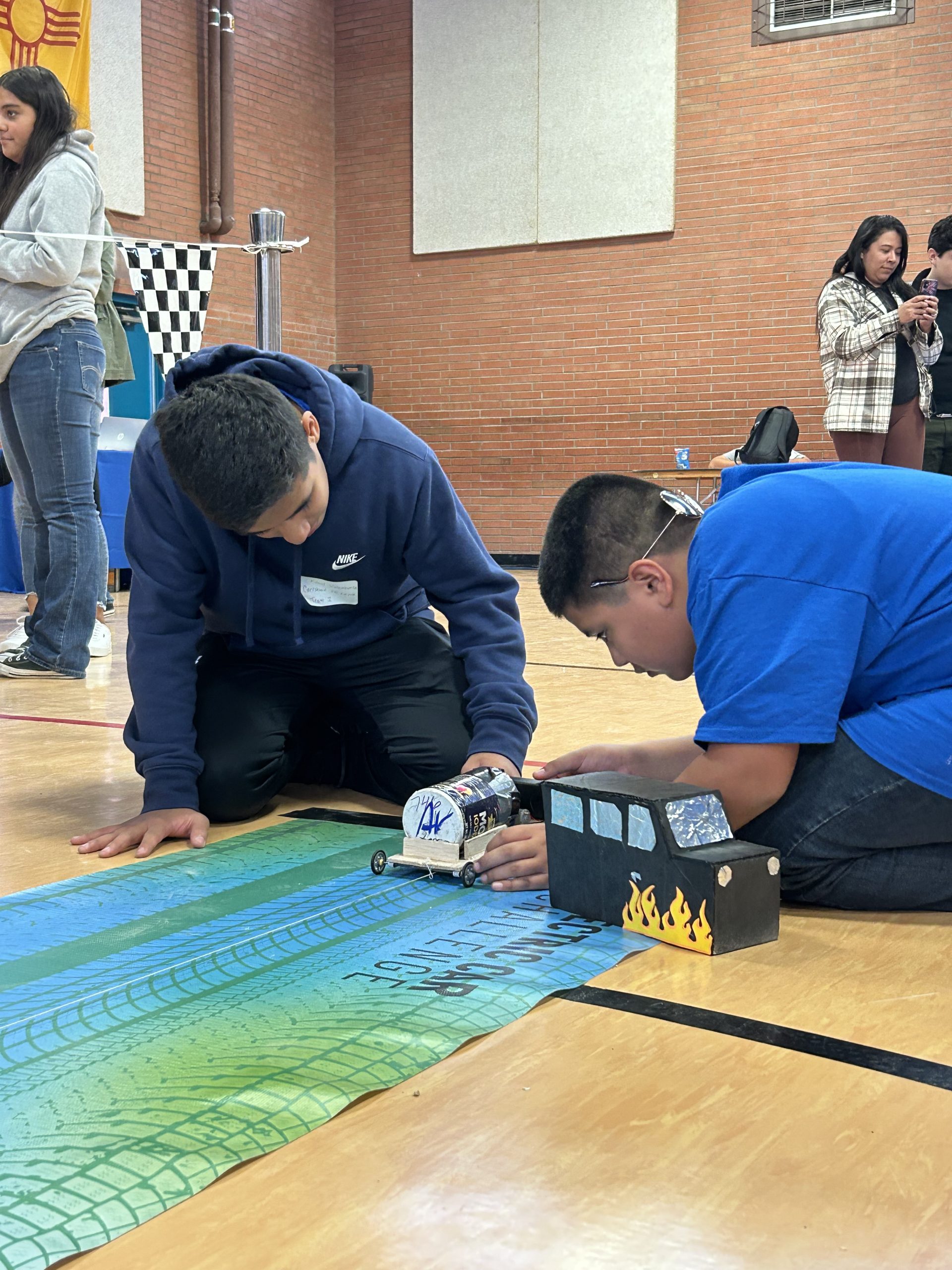 Students from Carlsbad Middle School make alterations to their electric car after a trial run in the 2023 New Mexico Electric Car Challenge. 