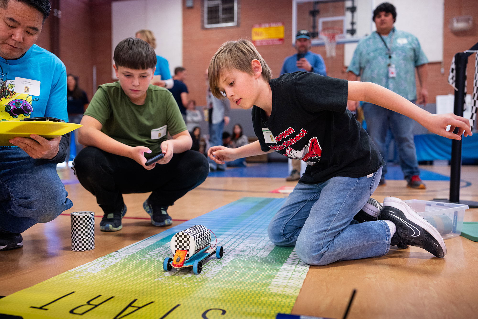 Pablo Sandoval, right, and Tomas Giron, students from Jefferson Middle School in Albuquerque, let their car loose under the watchful eye of Sandia National Laboratories volunteer Justin Teo during the New Mexico Electric Car Challenge on Nov. 15. 