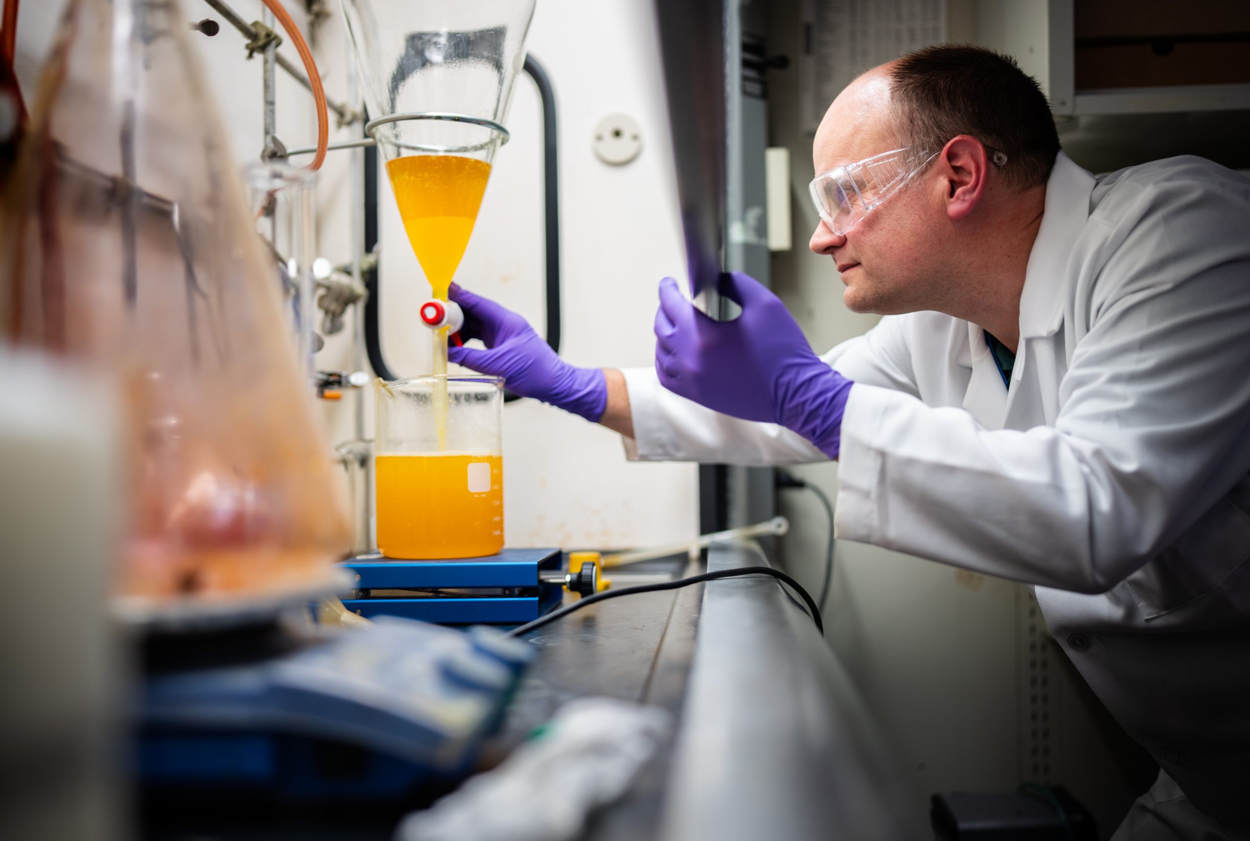 Sandia National Laboratories chemist Chad Staiger uses a separatory funnel to remove byproduct from the synthesis of a molecule.