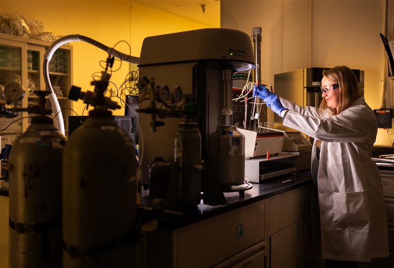 Melissa Mills prepares sample tubes for degassing by heating the sample to remove anything in the pores. She will place the tubes in an instrument with the liquid nitrogen bath to measure gas adsorption and gather surface area and pore size distribution data.
