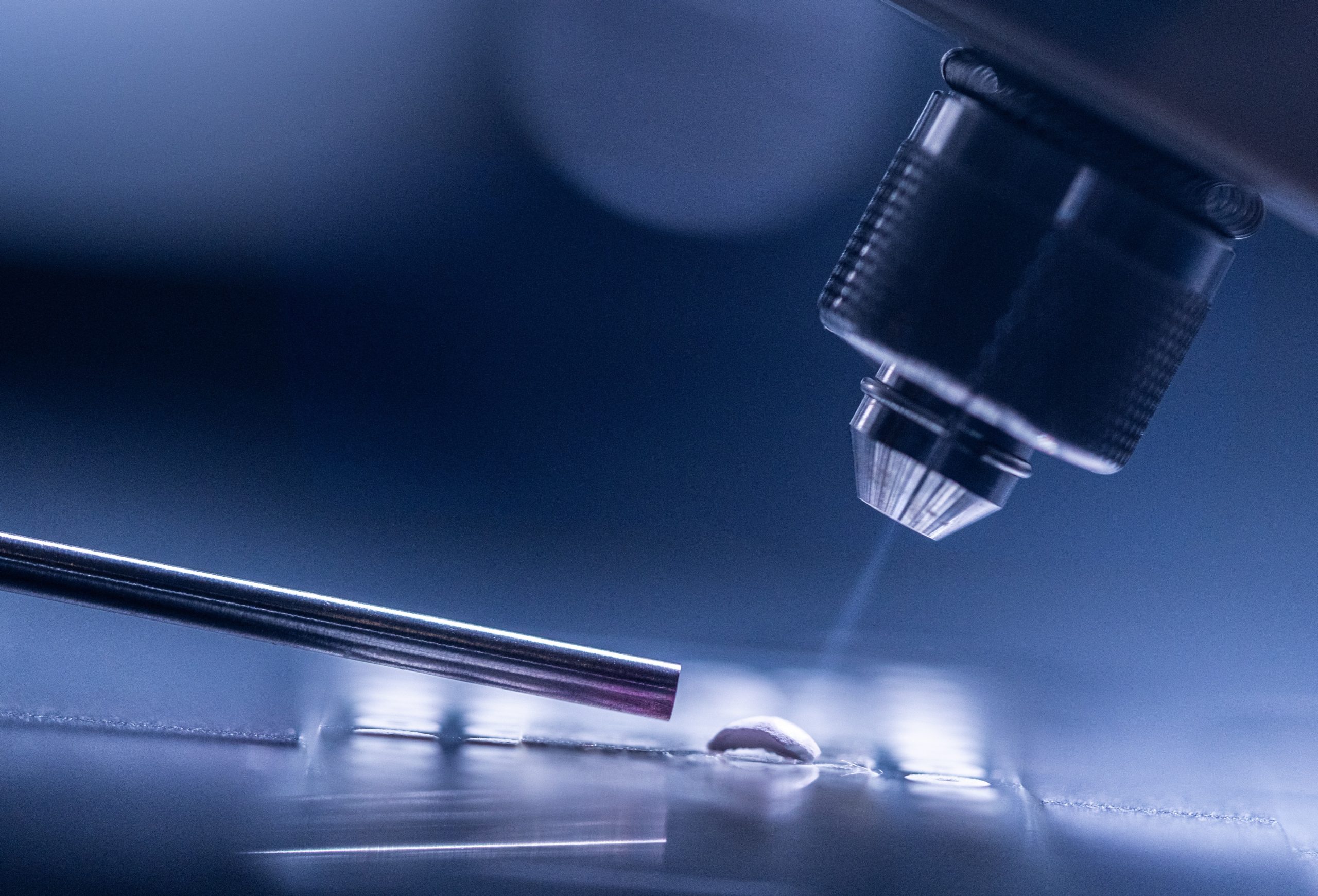 An adsorbent particle containing the analyte of interest (e.g. PFAS) is sprayed with charged droplets that splash off the surface and are captured by a metal tube and carried into a mass spectrometer for analysis. This process is known as desorption electrospray ionization