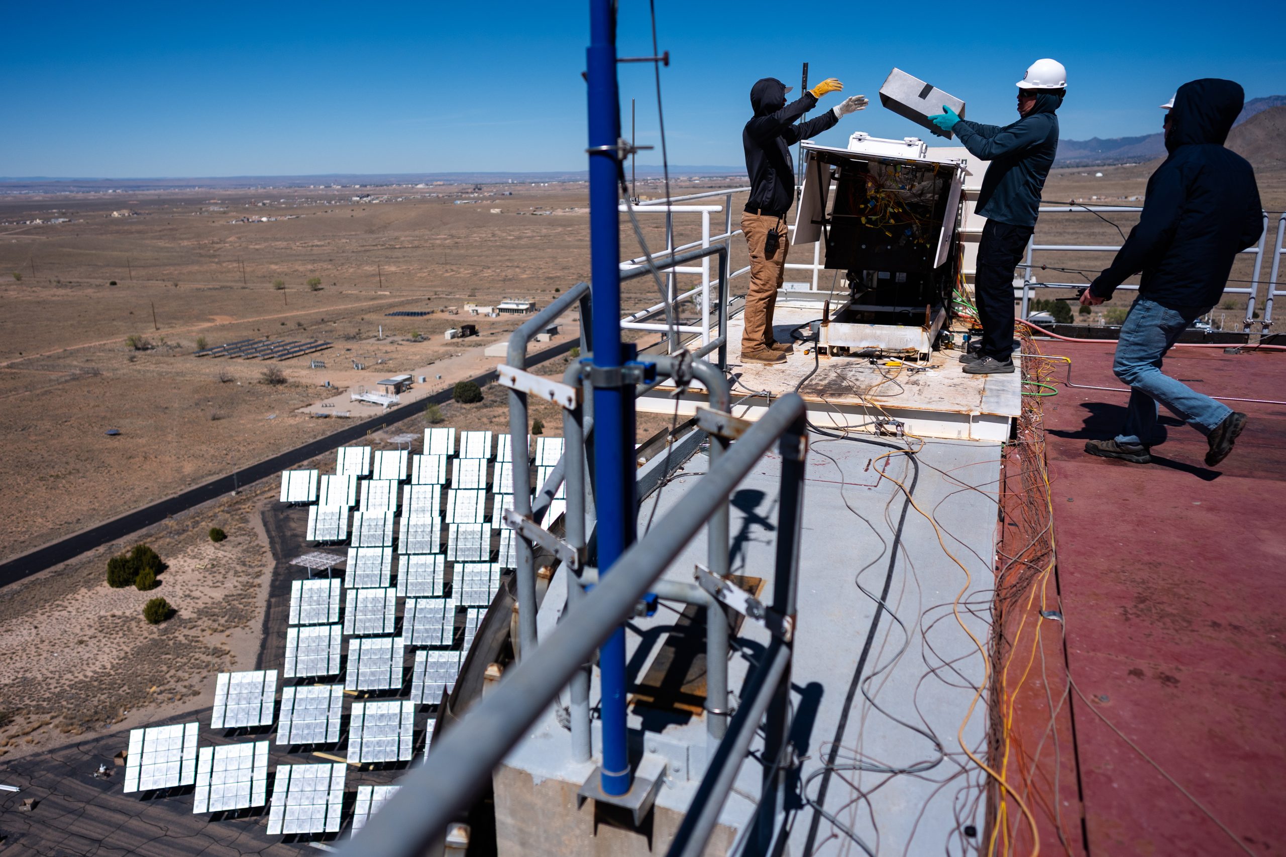 Sandia National Laboratories engineers Aaron Overacker, left, Todd Arterburn, and Lockheed Martin engineer Derek Shannon, right, get ready to test heat shield material samples at the National Solar Thermal Test Facility for NASA’s Dragonfly mission to Titan.