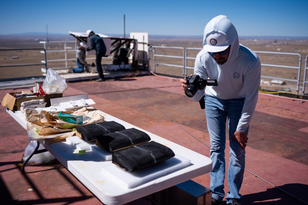 Lockheed Martin Space engineer Nick Courtney photographs samples of heat shield material after testing at Sandia National Laboratories’ National Solar Thermal Test Facility. (Photo by Craig Fritz) Click on the thumbnail for a high-resolution image.