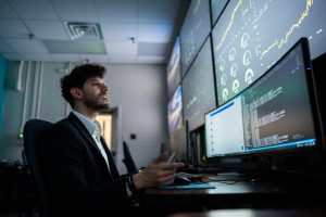 <strong>Sandia National Laboratories engineer Rachid Darbali-Zamora monitors an AI-driven distributed energy resource management system in the control room at Sandia's Distributed Energy Technologies Laboratory. The dashboard displays real-time controls designed to help keep voltage within operating limits as grid conditions change.</strong> (Photo by Craig Fritz) Click on the thumbnail for a high-resolution image.