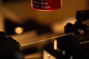 <strong>At Sandia National Laboratories, standard optical fiber is simultaneously heated over a flame and stretched by two motorized stages to produce an optical nanofiber. </strong>(Photo by Craig Fritz) Click on the thumbnail for a high-resolution image.
