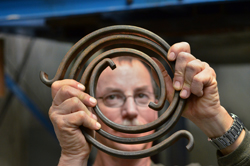 Elton Wright shows a torsional spring that’s used to simulate the rotational vibration of the drill string in a Sandia experiment.