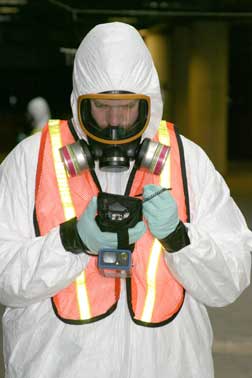 A technician outfitted in HazMat gear