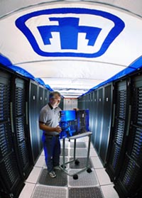 John Zepper inspects a Thunderbird supercomputer component under the
Sandia Thunderbird insignia.