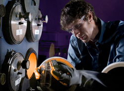 Sandia's Daniel Dedrick handles a complex metal hydride within an inert production and storage environment. Complex metal hydrides, along with many hydrogen storage materials, react readily when exposed to air and moisture. A Sandia-led project was initiated to quantify the reactivity of these materials to enable safe production, handling, storage, and utilization within the context of full-scale automotive applications.