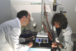 Sandia researcher May Nyman and post-doc  Travis Anderson examine the outcome of a niobium/tantalum solution.