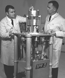 This photo, taken in the early 1960s, shows the reactor building and the original instrumentation building. The domed structure is the Reactor building, called the Kiva, and the metal building next to the Chevy Nomad is the Instrumentation Building. 
