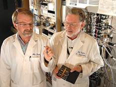 Sandia researchers Mike Thomas, left, and Bob Hughes work with the Wide-Range Hydrogen Sensor, developed at Sandia and commercialized by H2scan after a complex tech transfer process.