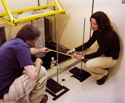 Jason Jones and Tina Nenoff set up an experiment in a testing cell at the Gamma Irradiation Facility.
